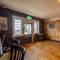 The interior games area at The Walkford in Walkford, with two dartboards on a wood panelled wall, and bar stool seating.