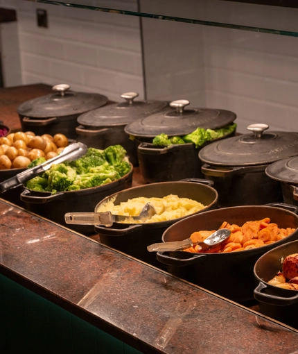 An image focusing on the interior carvery area with a selection of vegetables at The Farmhouse Kitchen Willington.