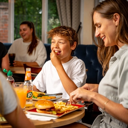 A family sat at an indoor table enjoying a meal and drinks at a Hungry Horse venue.