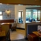 An interior restaurant seating area at The Steam Turbine in Rugby, with upholstered booth seating, and framed artwork on the walls.