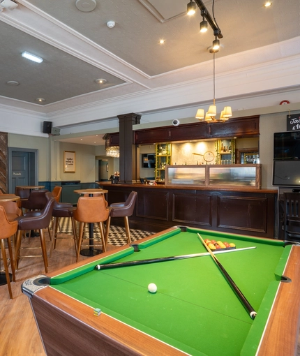 The interior pub games are with pool table, seating and bar area with TV at the Black Horse.