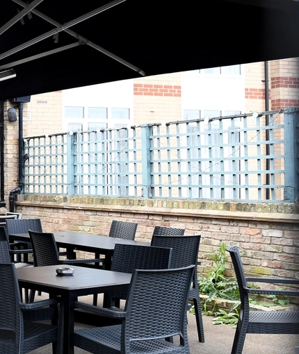 The exterior beer garden seating area with the rear of the venue in the background at The Duke Of Cambridge.