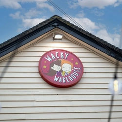 A close up view of the Wacky Warehouse sign on the exterior facade of The Vine Inn.