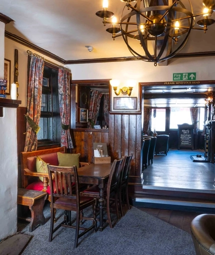 The interior restaurant seating area with fireplace, at Ye Olde Mitre.