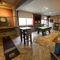 Interior dining area of a pub with a pool table, a TV and a dartboard.