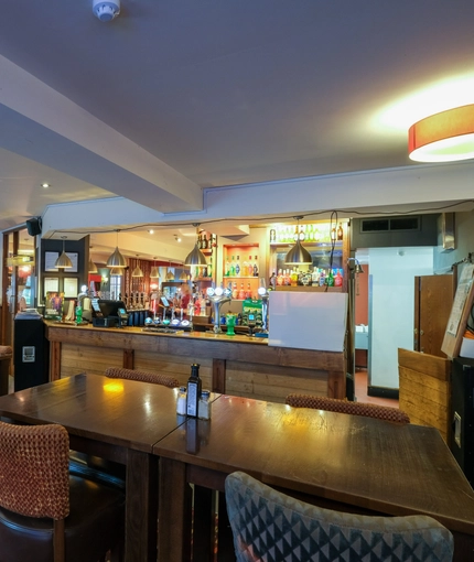 interior dining area of a pub with a bar and a TV