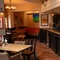 The bar and interior restaurant seating area at The Amington in Tamworth, with bottles of alcoholic spirits on a wooden shelf behind the counter, and TVs on the walls.
