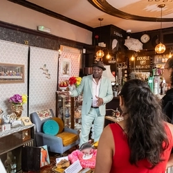 A historian 'Tony Fairweather' showing Greene King staff a staged Windrush Front Room during Black history month.
