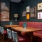 An interior restaurant seating area at the Tredegar Arms, with an upholstered booth seat, and framed artwork on the wall.
