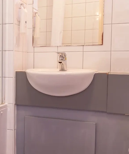 The interior bathroom with sink, bath and toilet at the Kingstown Hotel.