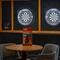 Two illuminated dartboards on the wall of one of the interior restaurant seating areas at The Heron.