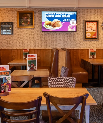 The interior restaurant and seating area with TV at the Woodlands Edge.
