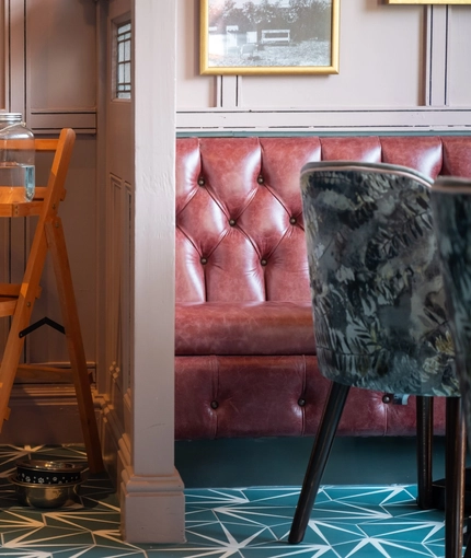 The dog treat station at The Victoria, with rolled up blankets, glass jars filled with dog treats, water bowls, and a water dispenser.