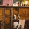 The wood panelled interior restaurant seating area at the Masons Arms, with upholstered booth seating, a fireplace, and grape vines carved into the coving.