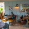 An interior restaurant seating area at the Golden Hind, with tiled flooring, wood panelled wall, and upholstered chairs.