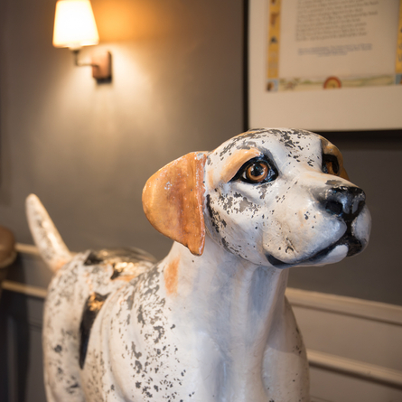 The interior decor focusing on a dog statue featured on the signage at The Blue Cap.