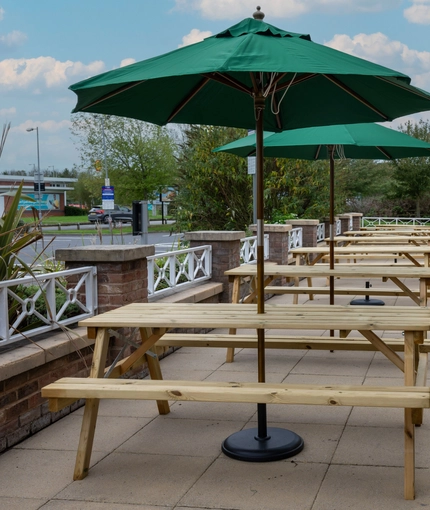 The exterior patio beer garden seating area with wooden benches at The Farmhouse Kitchen Willington.