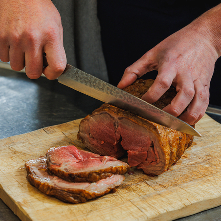 A Chef carving a joint of lamb at the carvery deck at Crafted Venues.