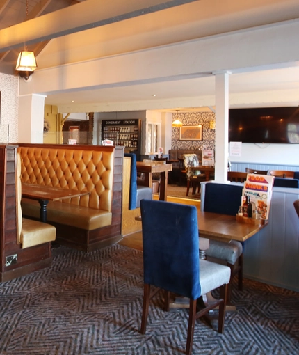 Interior dining area of a pub with a TV.