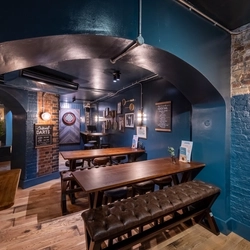 A bench near a dart board in the Prince Of Wales.