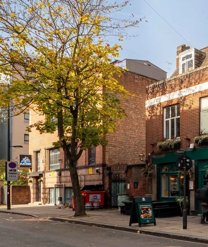 The exterior facade, signage, and seating area of the Lucas Arms in London.