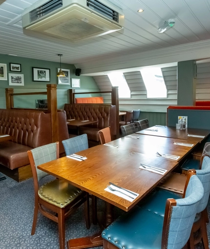 Interior dining area of a pub with a few TVs.