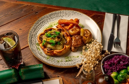 A plated Mushroom Galette with a range of sides on a wooden table.