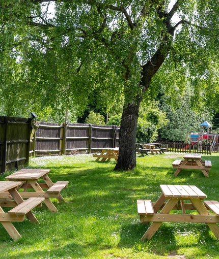 Exterior beer garden of a pub with a seating area and a play area.