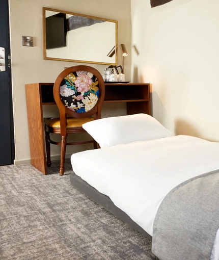 A bed in a hotel room of The Narborough Arms.