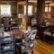 The interior restaurant seating area at The Kings Arms in Sandford-On-Thames, with wooden flooring and beams, upholstered chairs, and exposed brick wall details.