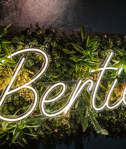 A neon sign on the wall that says 'Berties'.