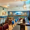 The interior seating area with the pub games area coming into view in the background including pool tables, a dart board, slot machine and TV at the Armstrongs. 