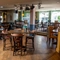 The interior restaurant seating area of the Rudds Arms; with TVs on the walls, and stage lights hanging on the ceiling.