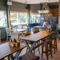 The interior restaurant seating area at The Man On The Moon, with upholstered seating, wooden tables and a TV on the walls.