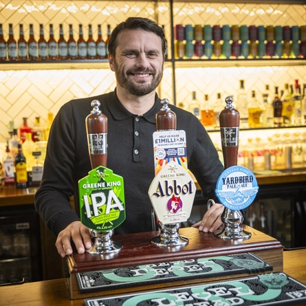 A man standing behind a bar.