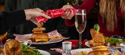 plates of food and a few drinks sitting on a wooden table of a pub