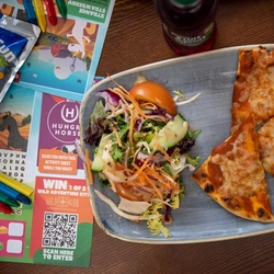 A platter of pizza and salad on a table of a pub