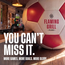 A banner promoting the new football season at Flaming Grill venues. The banner shows an interior of a Flaming Grill-branded sports bar featuring a giant football-shaped wall installation beside the bar. Large white text reads “YOU CAN’T MISS IT.” with smaller text underneath stating “MORE GAMES. MORE GOALS. MORE GLORY.” A television screen showing a football match is visible in the background above beer taps and shelves of bottles.