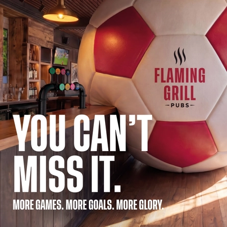 A banner promoting the new football season at Flaming Grill venues. The banner shows an interior of a Flaming Grill-branded sports bar featuring a giant football-shaped wall installation beside the bar. Large white text reads “YOU CAN’T MISS IT.” with smaller text underneath stating “MORE GAMES. MORE GOALS. MORE GLORY.” A television screen showing a football match is visible in the background above beer taps and shelves of bottles.