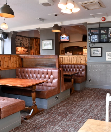Interior dining area of a pub with a TV.