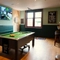 The interior games area at The Richmond Arms in Bournemouth, with a pool table; a dartboard; a TV on the wall; and bar stool seating.