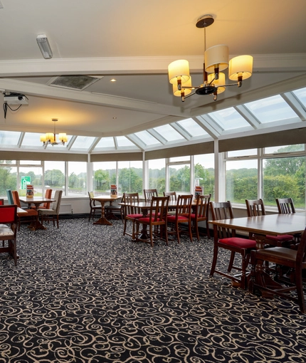 Interior dining area of a pub in a conservatory.