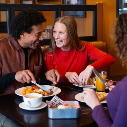 A family enjoying a meal and drinks in the interior restaurant from the new Spring/Summer menu at Flaming Grill.