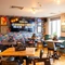 The interior restaurant seating area at the Counting House, with brightly coloured wallpaper, and a TV on the wall.