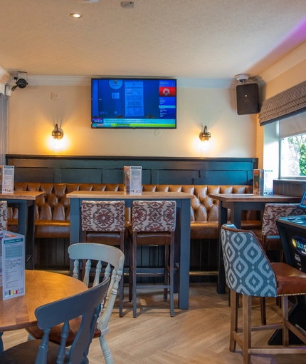 The interior restaurant and seating area with TV and slot machine at the Poachers 