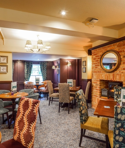 The interior restaurant seating area with feature fireplace at The Two Greens.