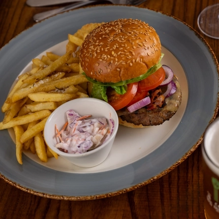 plates of food and glasses sitting on a wooden table of a pub