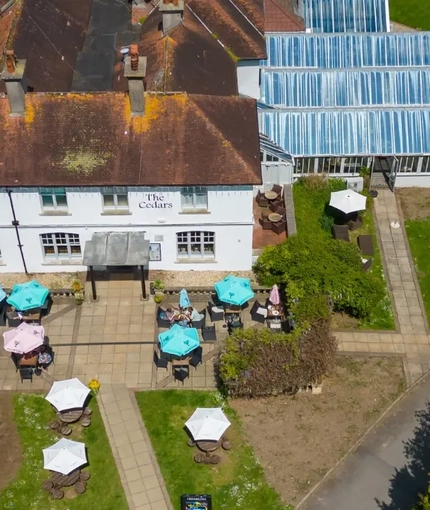 A birdseye view of the exterior facade and seating area at the Cedars Inn.