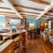 An interior restaurant seating area at The Walkford, with an upholstered booth seat along one wall, and wooden beams on the ceiling.