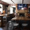 Interior dining area of a pub with a TV and a fireplace.